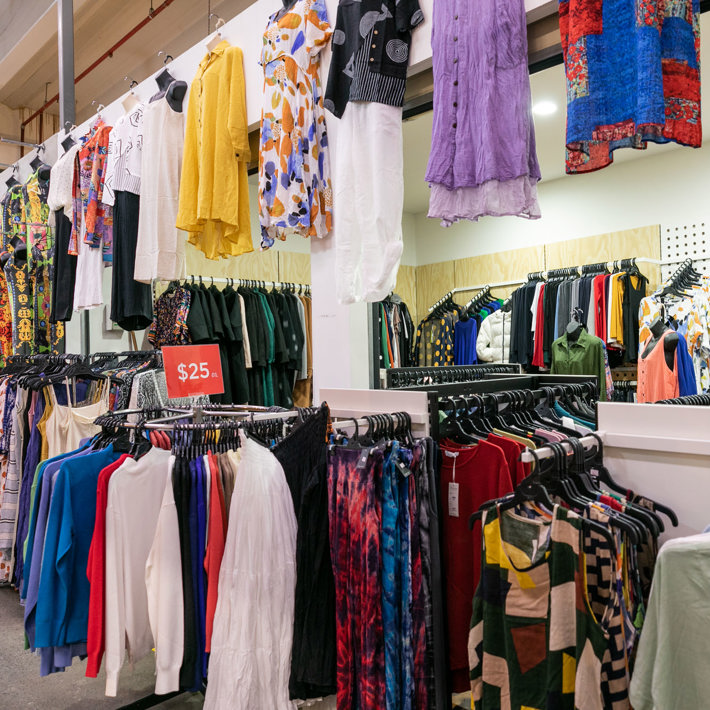 The image depicts a variety of clothing items displayed on hangers in a retail store